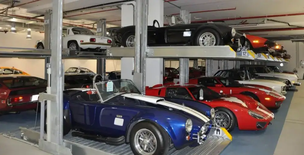 Classic sports cars parked on two-level car stacker lifts at the Tomini Classics garage in Al Barsha, Dubai