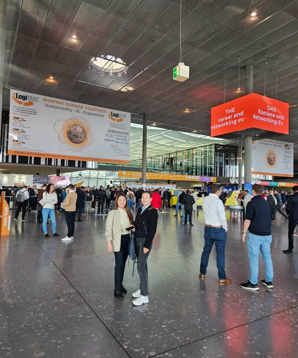 ALS team members in the LogiMAT 2024 entrance hall at Messe Stuttgart under “Shaping Change Together” banners