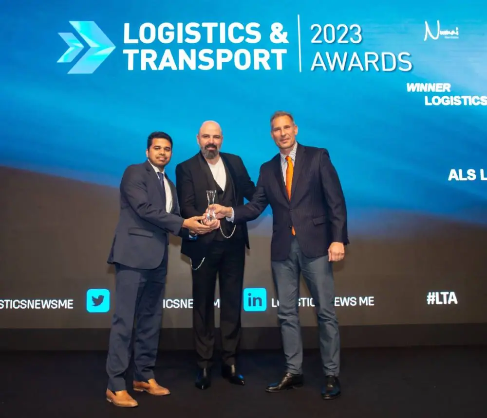 ALS team sharing the glass Logistics Innovator of the Year trophy on stage at the Logistics & Transport Awards 2023
