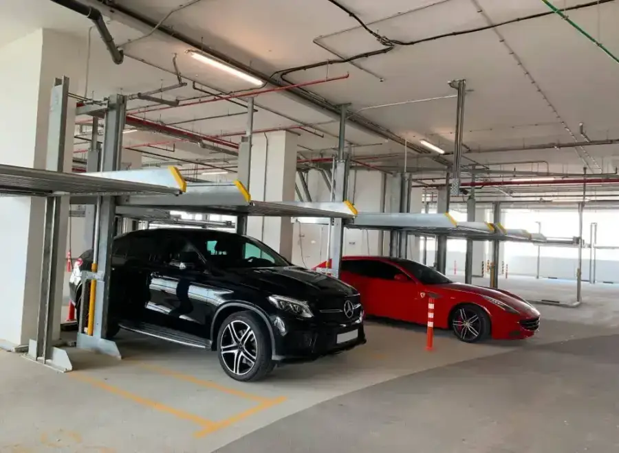 Two-level car stacker lifts with parked cars in a residential car park in Jumeirah Village Circle, Dubai